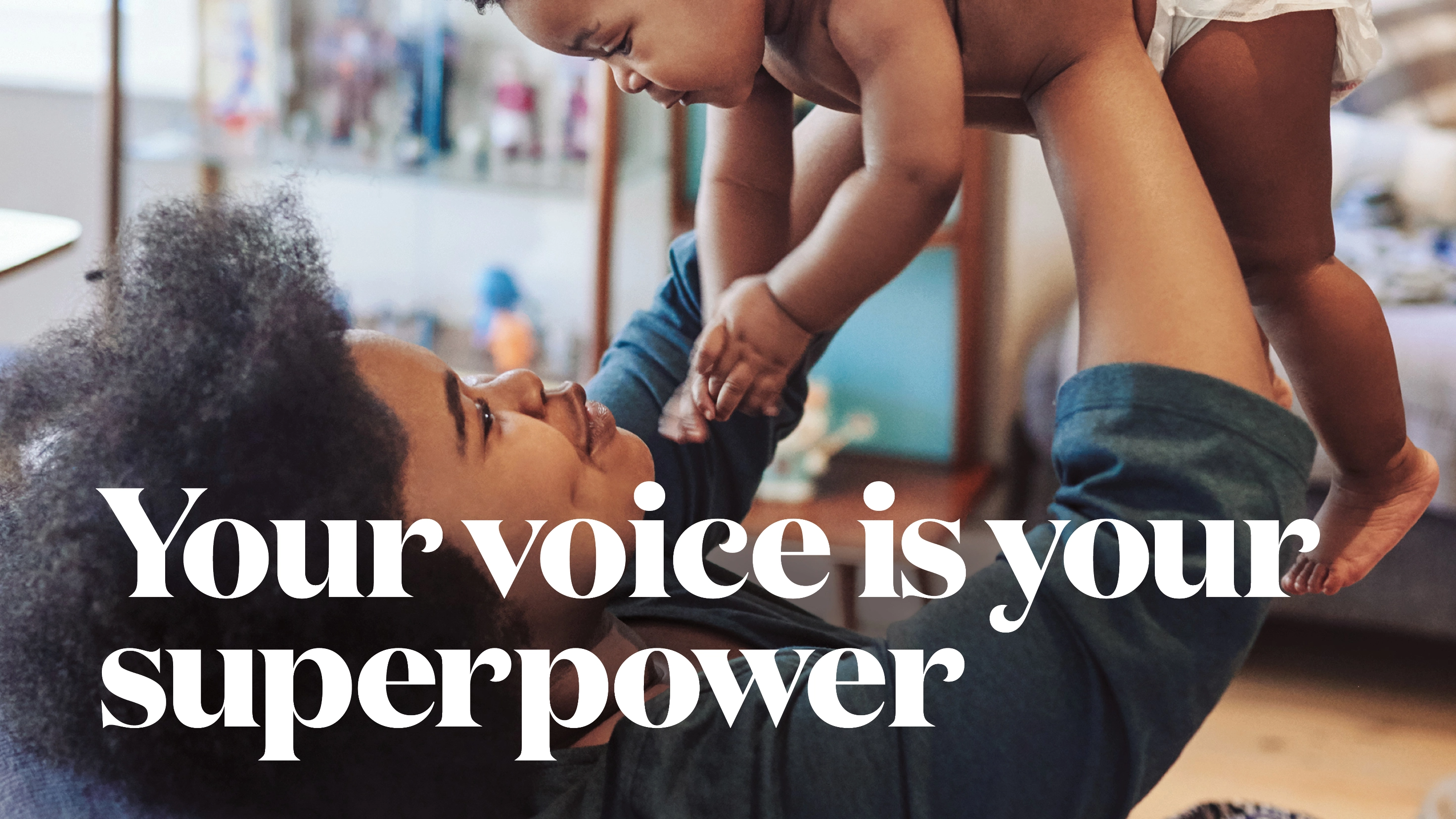 A new parent holds their infant with text reading "Your voice is your superpower".