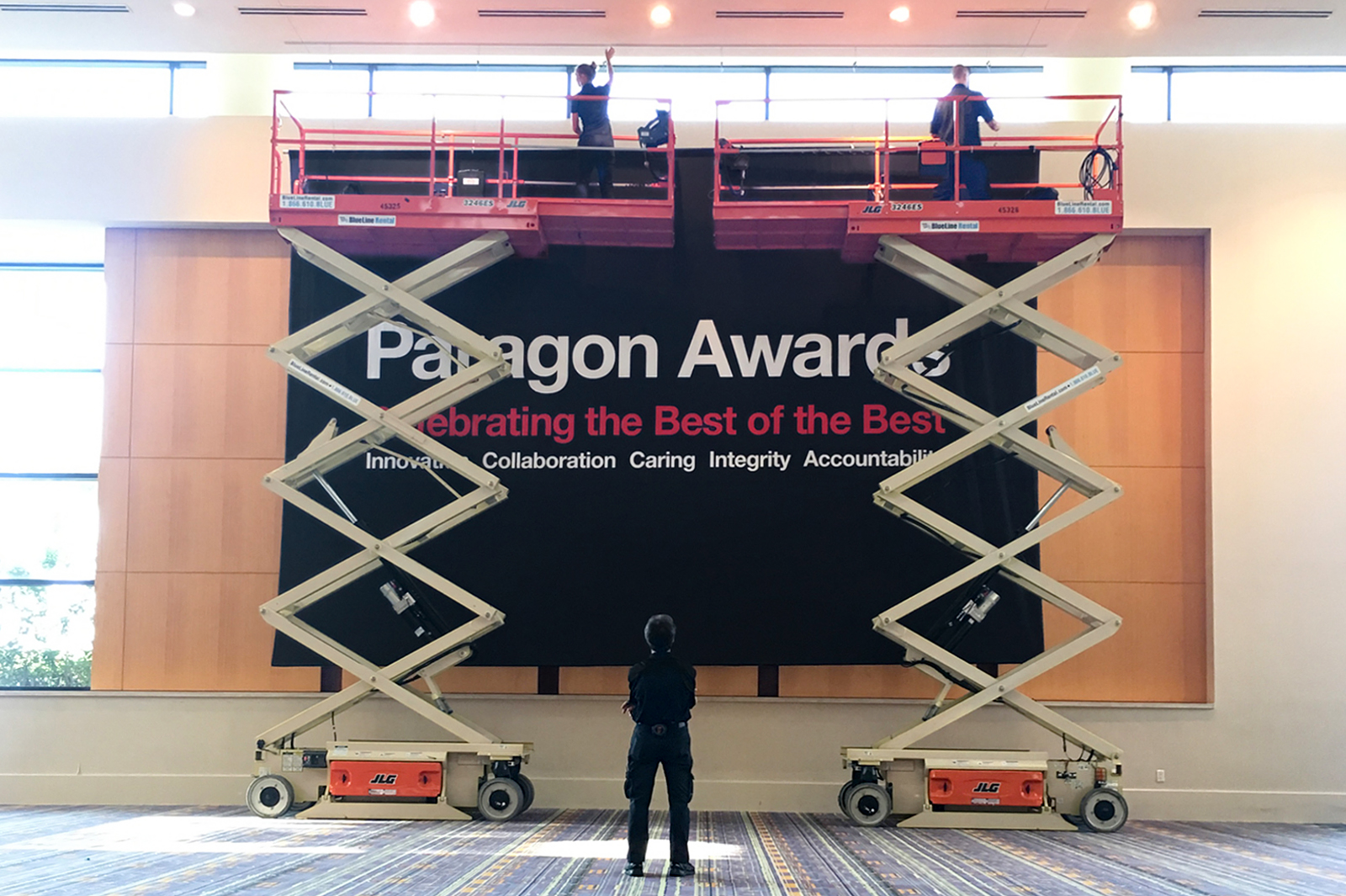 CVS Paragon Awards banner being raised by add ventures crews with cherry pickers.