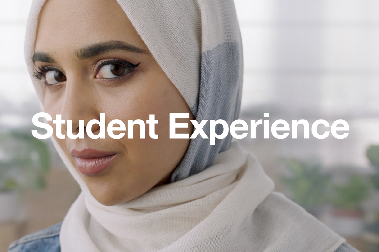 student in head scarf with word student experience across screen