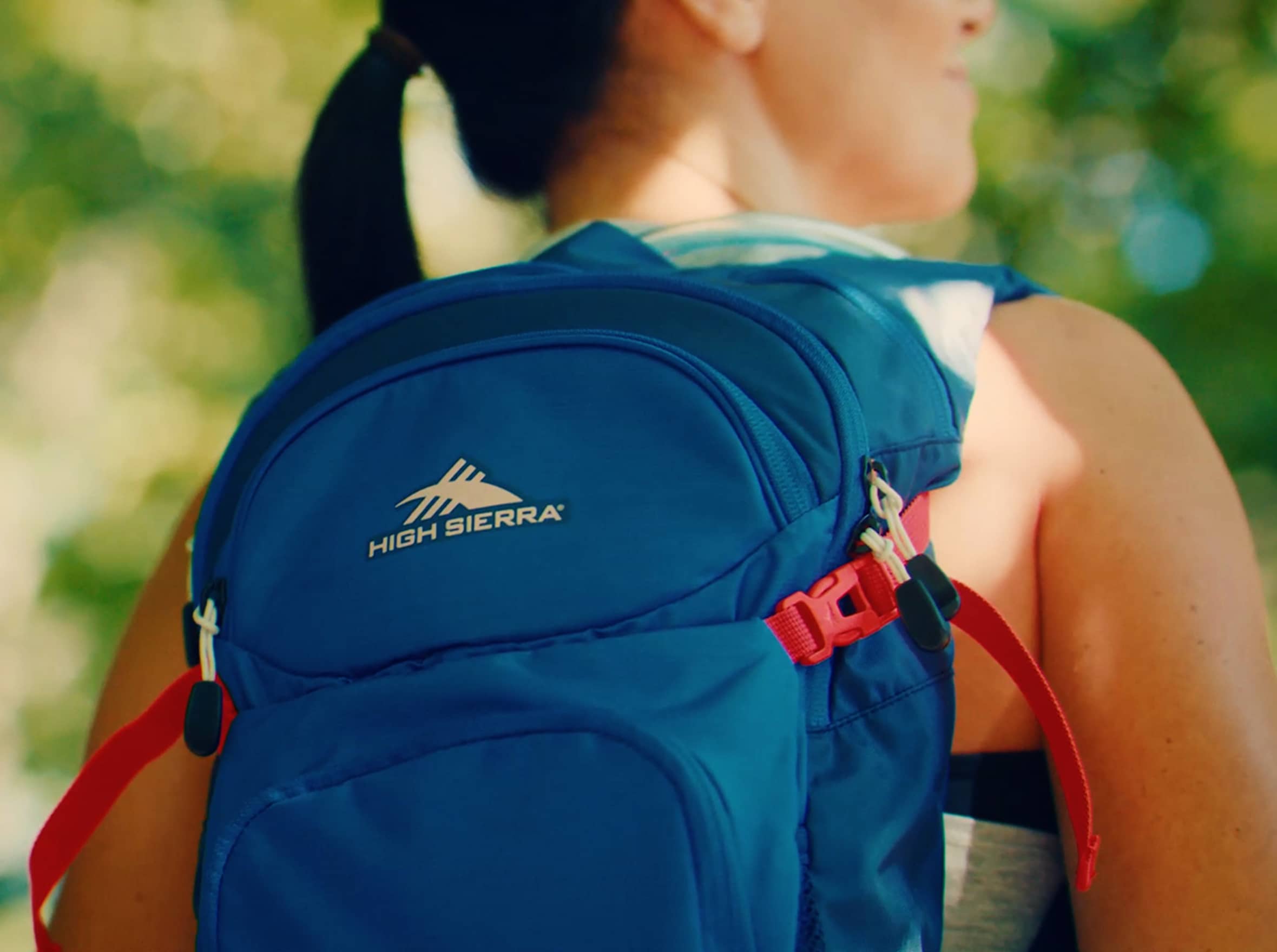 A girl wears a blue High Sierra backpack.