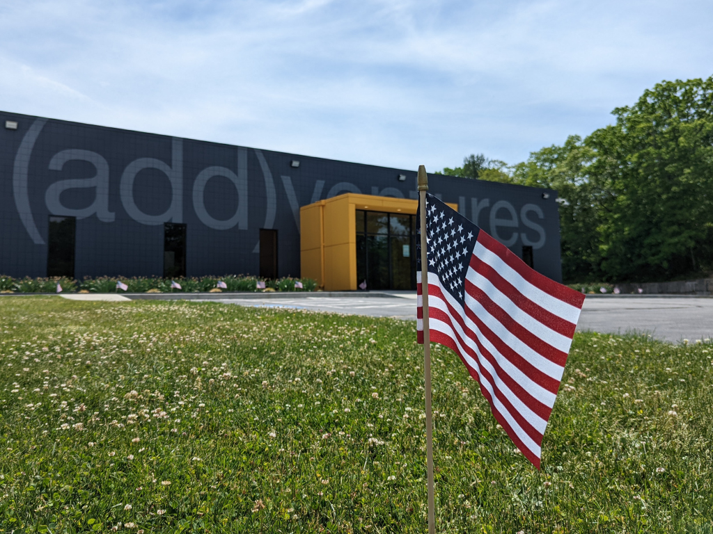 An American flag planted on the lawn of (add)ventures EPIC HQ